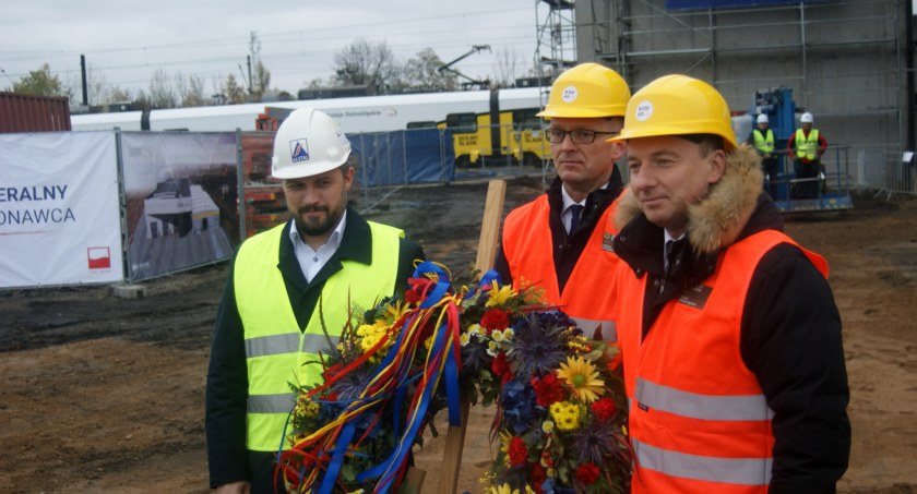 Zdjęcie: Zawieszenie wiechy na budowie hali Kolei Dolnośląskich przy ul. Pątnowskiej w Legnicy. Od lewej: dyrektor Radosław Bodnar z firmy Alstal (wykonawca), Damian Stawikowski - prezes KD i Tymoteusz Myrda - członek zarządu województwa dolnośląskiego (fot. Piotr Kanikowski)
