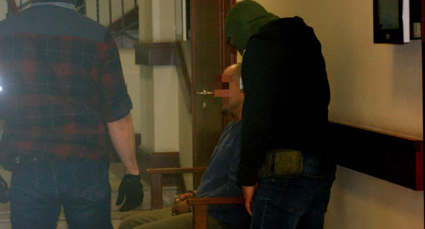 Zdjęcie: Łukasz C. z policjantami w Sądzie Rejonowym w Legnicy. Fot. Piotr Kanikowski