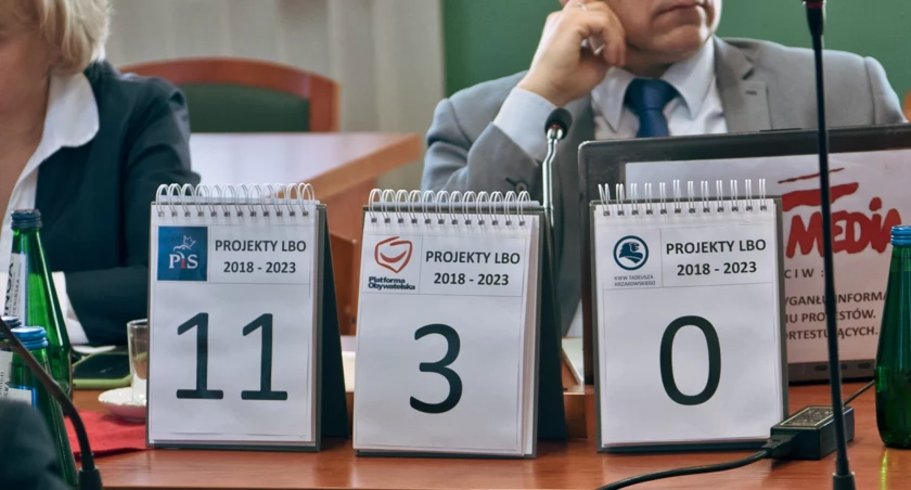Zdjęcie: Scenografia przy stanowisku radnego Andrzeja Lorenca (PiS) podczas sesji Rady Miejskiej Legnicy. Fot. Aga Jackiewicz