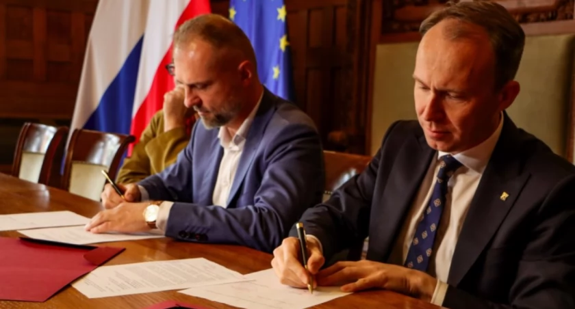 Zdjęcie: Prezydent Legnicy Maciej Kupaj i członek zarządu Dolnego Śląska Jarosław Rabczenko podpisują aneks do umowy. W głębi Jacek Głomb, dyrektor Teatru Modrzejewskiej w Legnicy. Fot. Urząd Miasta w Legnicy