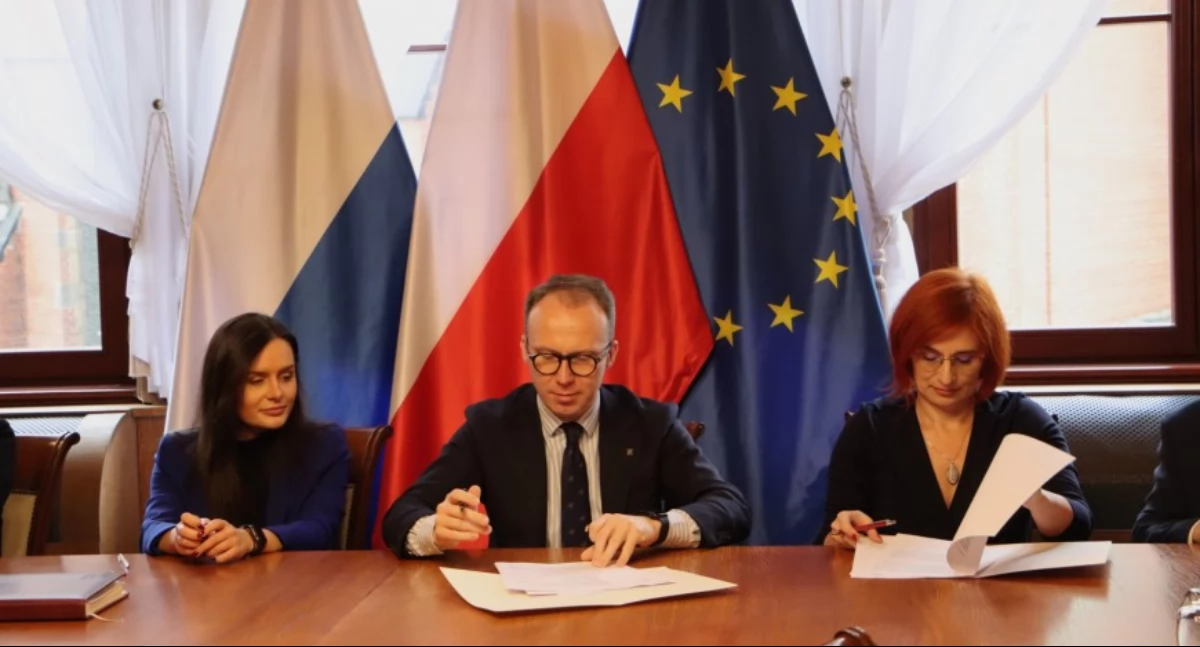 Zdjęcie: Podpisanie porozumienia. Od lewej: Aleksandra Krzeszewska (zastępczyni prezydenta Legnicy), Maciej Kupaj (prezydent Legnicy), Aneta Mazur (przewodnicząca Komisji Międzyzakładowej NSZZ Solidarność przy MOPS Legnica). Fot. Urząd Miasta w Legnicy
