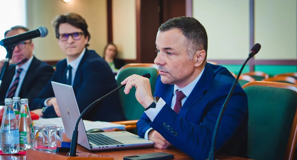 Zdjęcie: Sesja Rady Miejskiej Legnicy. Kacper Siwek, skarbnik miejski. W tle zastępca prezydenta Jacek Baszczyk i prezydent Maciej Kupaj. Fot. Aga Jackiewicz