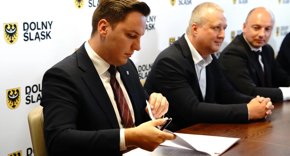 Zdjęcie: podpisanie umowy Do Przemkowa, położonego w powiecie polkowickim, dojadą pociągi Kolei Dolnośląskich - linię na odcinku Chocianów - Przemków Odlewnia wybuduje samorząd województwa dolnośląskiego i Dolnośląska Służba Dróg i Kolei.      Linia będzie przedłużeniem trasy kolejowej oddanej do użytku w grudniu 2022 roku. Pociągi wróciły wówczas do Chocianowa. Teraz powstanie jej dalszy ciąg - do Przemkowa. Ta miejscowość zniknęła z kolejowej mapy Polski ponad 30 lat temu.     - Konsekwentnie 