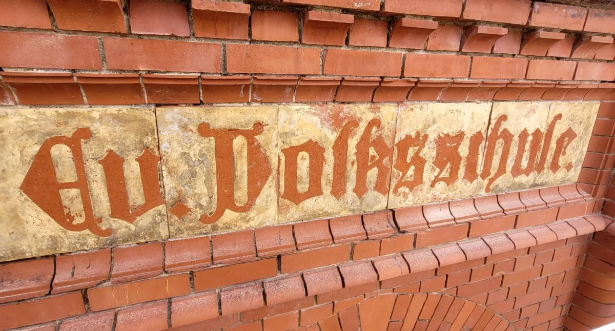 Zdjęcie: Fragment napisu odkrytego podczas remontu elewacji budynku Szkoły Podstawowej nr 1 w Złotoryi. Źródło: Facebook/ Nasza Złotoryja i Okolica - post Piotra Klimaszewskiego.