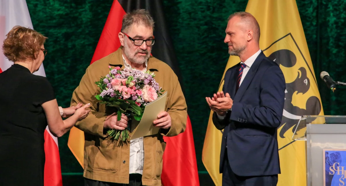 Zdjęcie: Gala 49. Nagrody Kulturalnej Śląska Kraju Związkowego Dolnej Saksonii w Starej Kopalni w Wałbrzychu. Jacek Głomb odbiera nagrodę z rąk Danieli Behrens i Jarosława Rabczenko. Źródło: Facebook/ Maciej Kupaj - Prezydent Miasta Legnicy