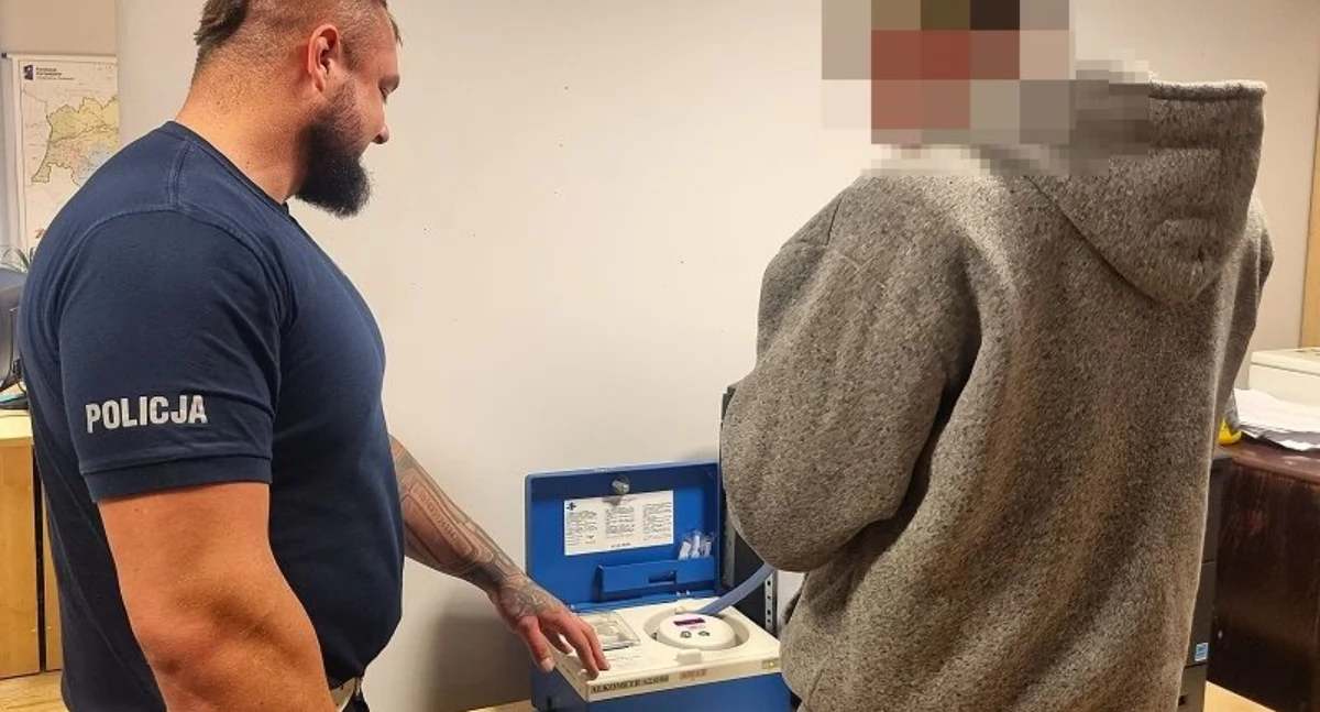 Zdjęcie: Policjant z zatrzymanym kierowcą podczas badania alkomatem. Fot. Komenda Miejska Policji w Legnicy
